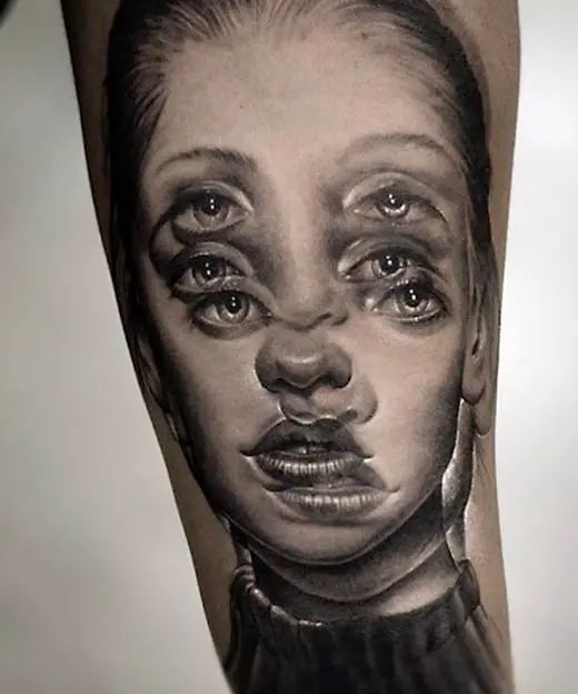 Face tattoo with overlapping eyes.