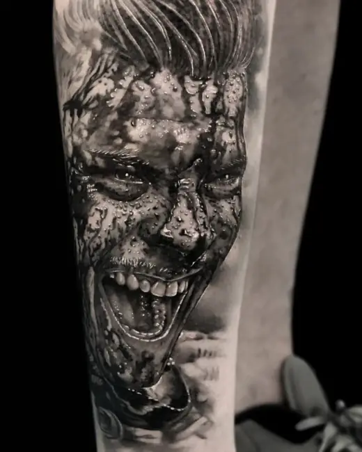 Black-and-grey realism tattoo of the Joker, wet and smiling